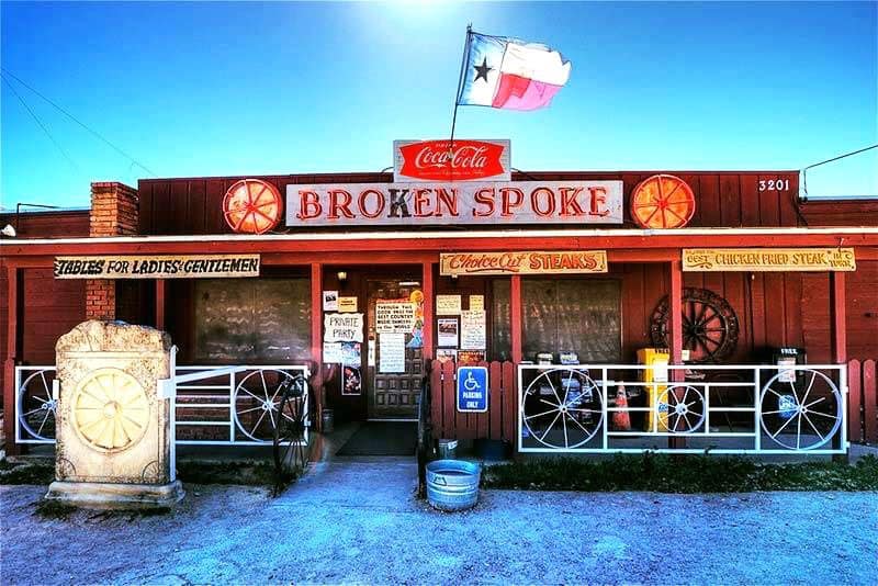 Broken Spoke honky-tonk at sunset in Austin, Texas – iconic red building with Texas flag