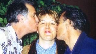 Tim Alexander, Debra Peters, and Santiago Jimenez Jr. sharing a playful kiss at an accordion event