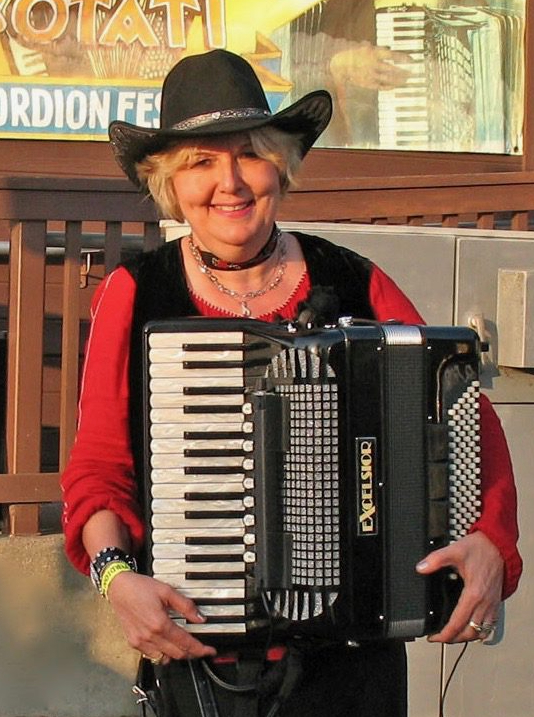 Debra Peters, piano accordion teacher and performer, holding her accordion at an accordion festival